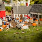 Halloween-koristeltu LEGO-miniatyyrikylä Legoland Billundissa, jossa näkyy kurpitsoja, kummituksia ja pieniä rakennuksia.