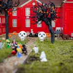 Halloween-koristeltu LEGO-miniatyyrimaailma Legoland Billundissa, jossa näkyy kummituksia, pääkalloja, kurpitsoja ja mustia puita.
